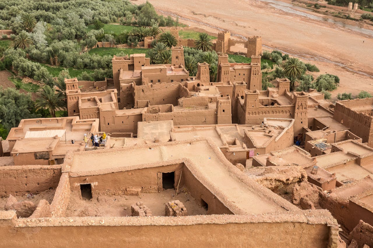 Discover the historic Aït Benhaddou, Morocco's iconic kasbah overlooking lush palm groves.